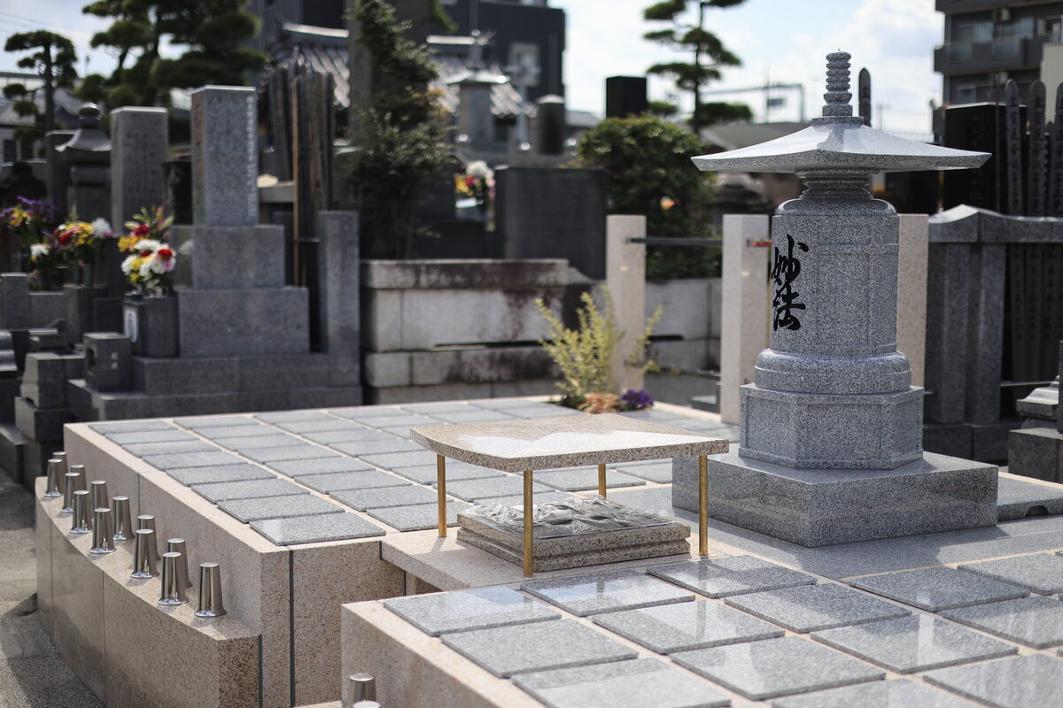 城立寺の樹木葬墓地。御影石の銘板が並び、中央に供養塔が建つ