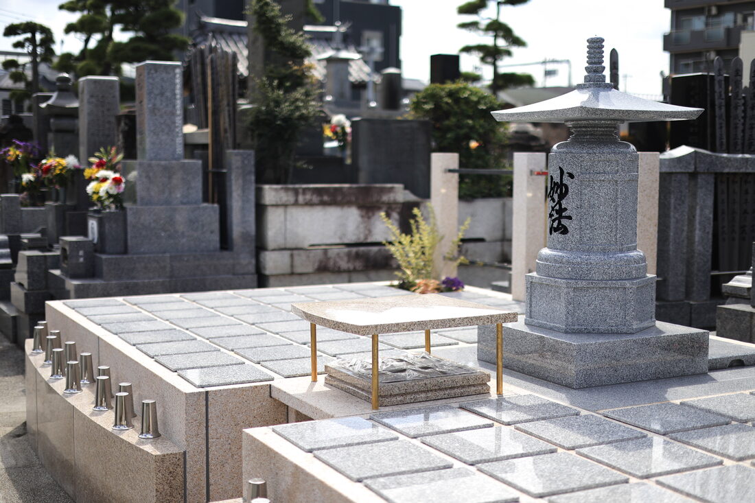 城立寺の樹木葬墓地。御影石の銘板が並び、中央に供養塔が建つ
